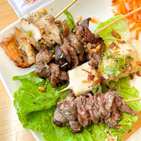 Vietvana Pho Noodle House's grilled meat and tofu skewers on lettuce with pickled carrots.
